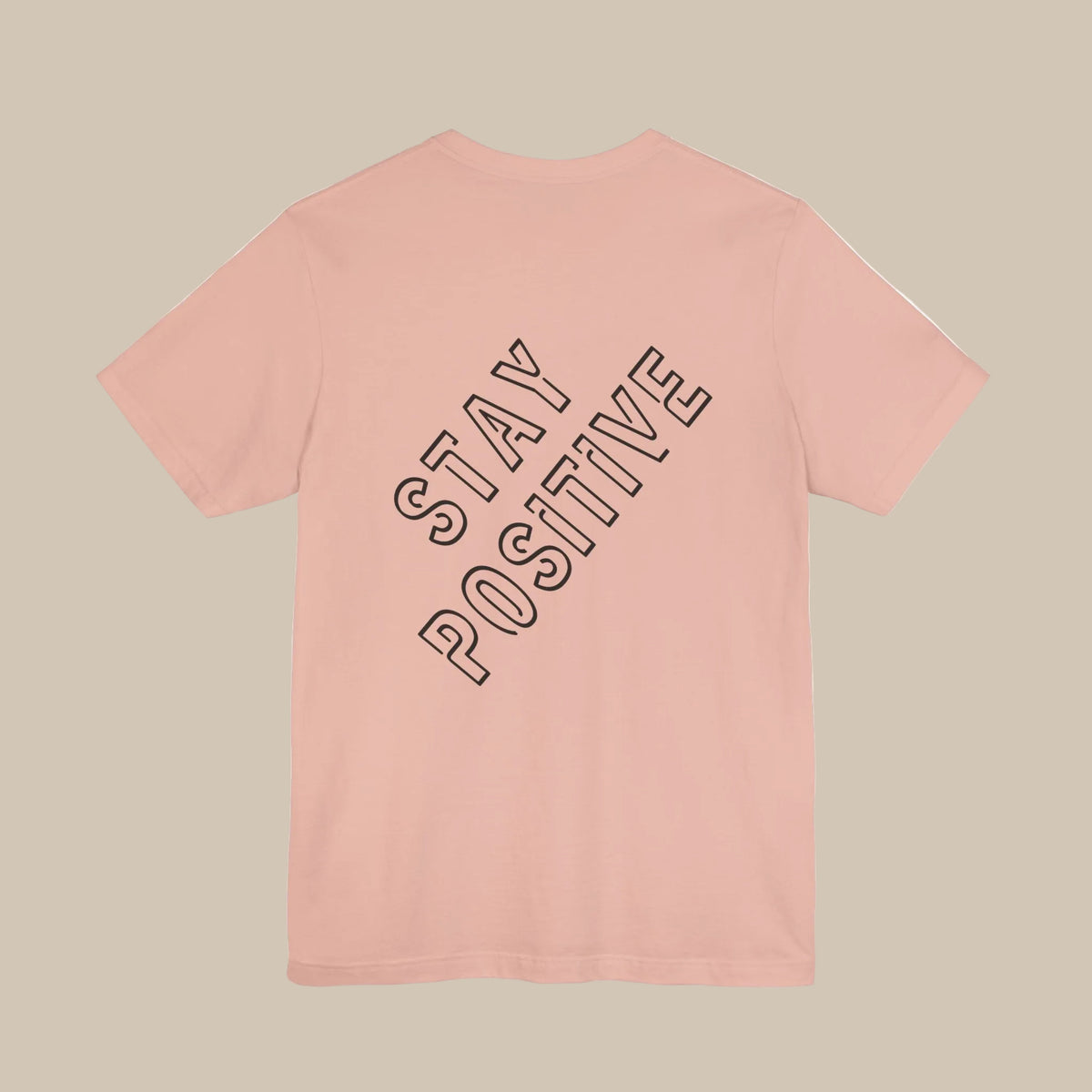 Pink t-shirt with 'Stay Positive' backprint text on a pink background