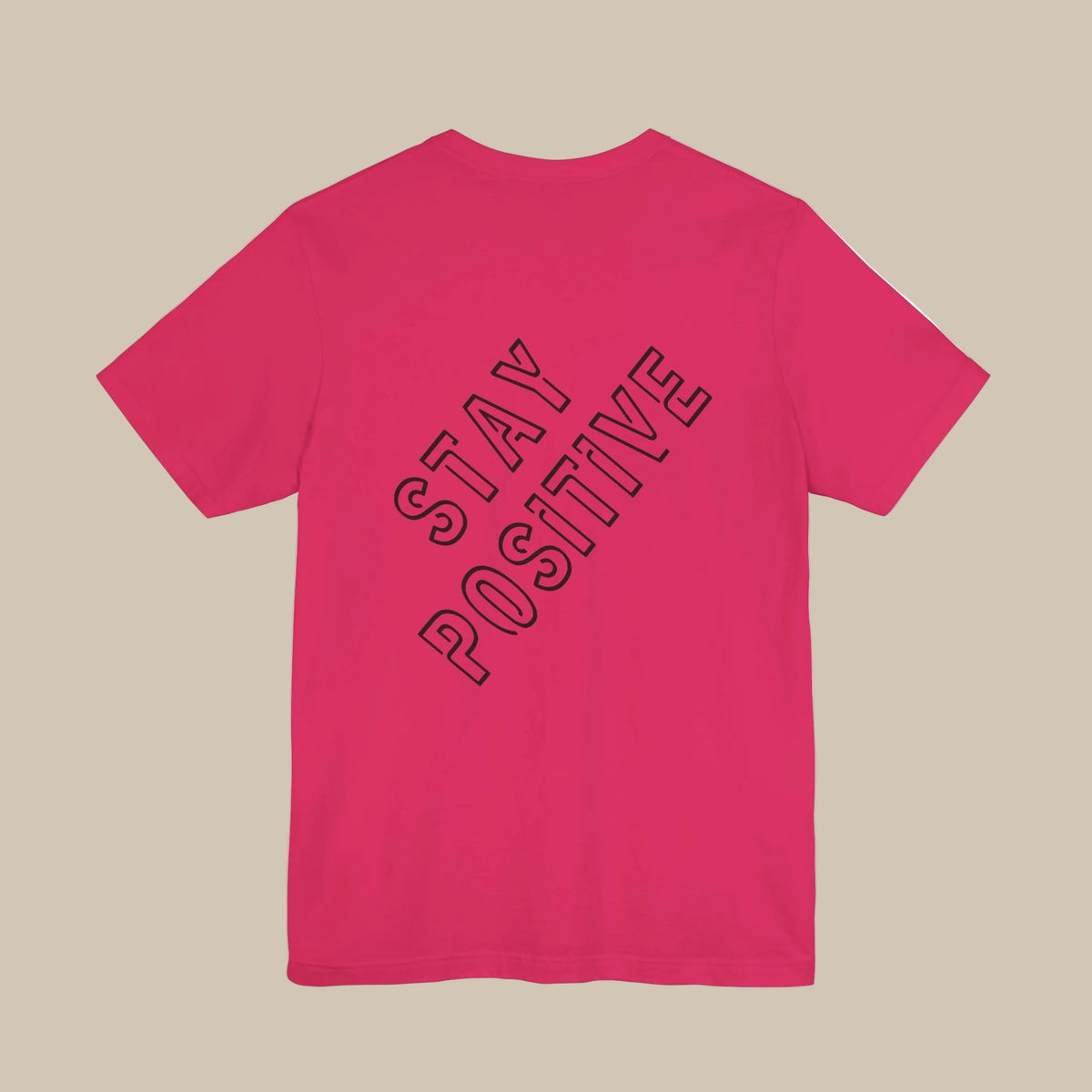 Pink t-shirt with 'Stay Positive' backprint text against a pink background